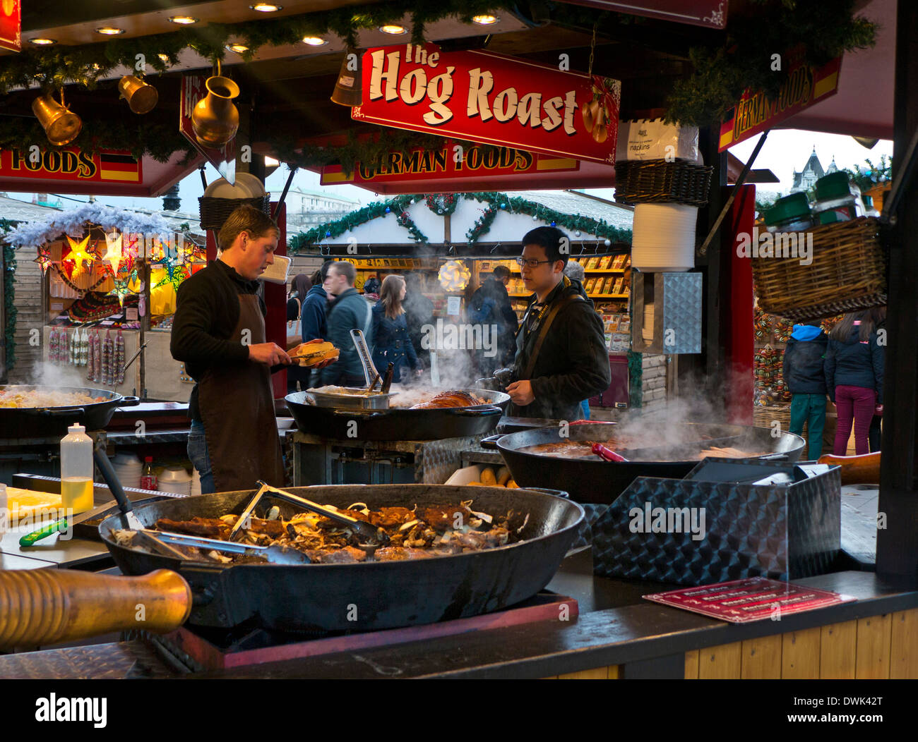Weihnachtsmarkt London Food Hog Road Winter Stall South Bank Thames Walk Deutscher Weihnachtsmarkt Imbiss zum Mitnehmen Schweinebraten & Besucher London Großbritannien Stockfoto