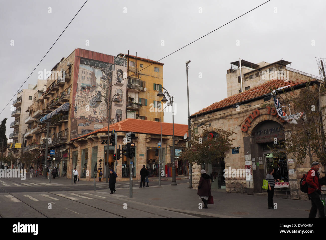 Einkaufen entlang Jaffa St, hohes Gebäude mit einem Wandbild gemalt, auf seiner Seite und Stadtbahn, Jerusalem Stockfoto