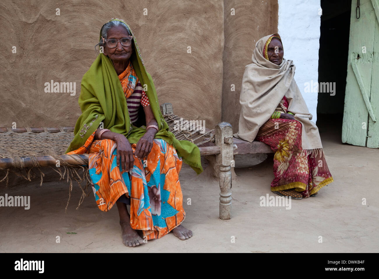 Bharatpur, Rajasthan, Indien. Zwei alte Rajasthani Frauen sitzen vor ihrem Haus. Stockfoto