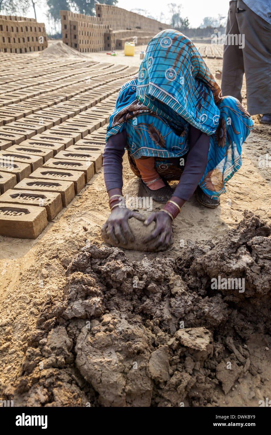 Rajasthan, Indien. Frau Vorbereitung Schlamm für Ehemann in die Ziegel Formen umzusetzen. Stockfoto