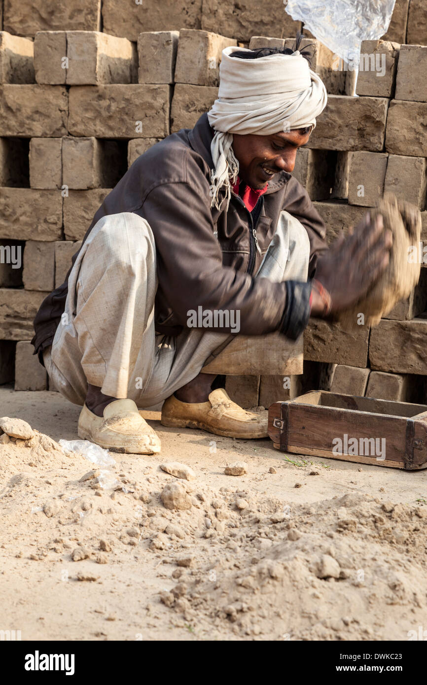 Rajasthan, Indien. Mann Schlamm in Backstein Form platzieren. Stockfoto