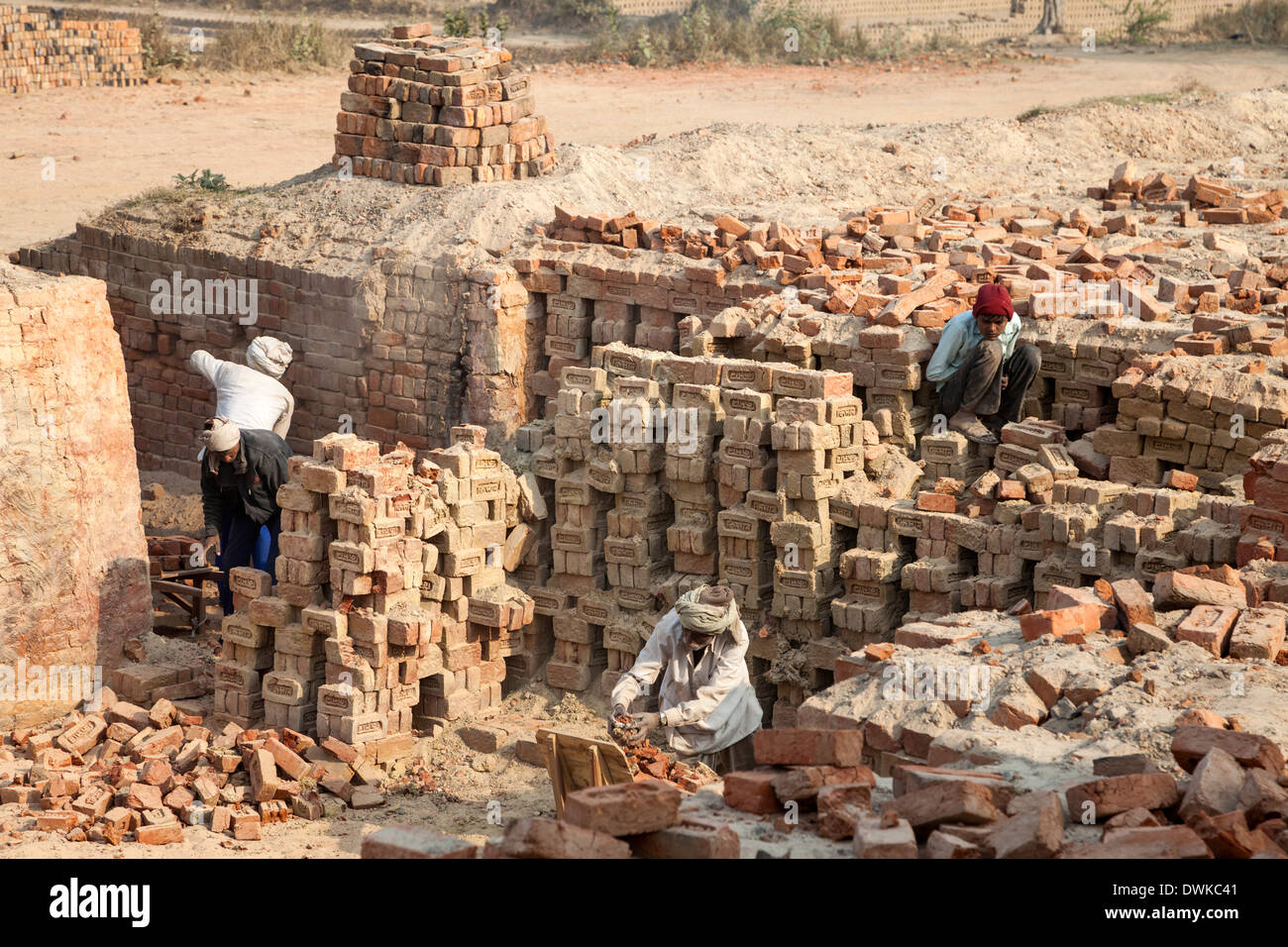Rajasthan, Indien. Männer entfernen von Steinen aus einem unterirdischen Ofen nach dem Brennen ist abgeschlossen. Stockfoto