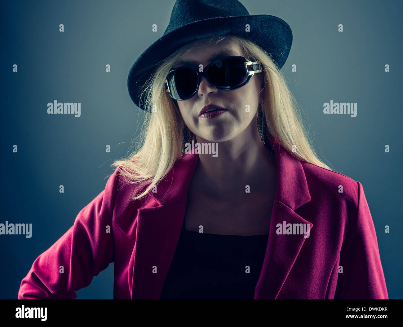 Urbane Reife Frau trägt eine Sonnenbrille und Hut, Studio gedreht Stockfoto