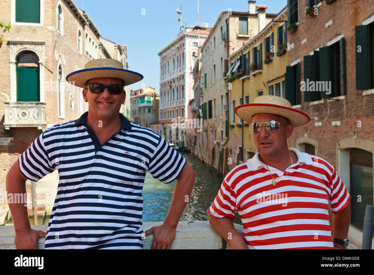 Nahaufnahme von Gondolieri auf Kanalbrücke mit rot und blau gestreiften Oberteilen, Venedig, Veneto, Italien, Europa Stockfoto