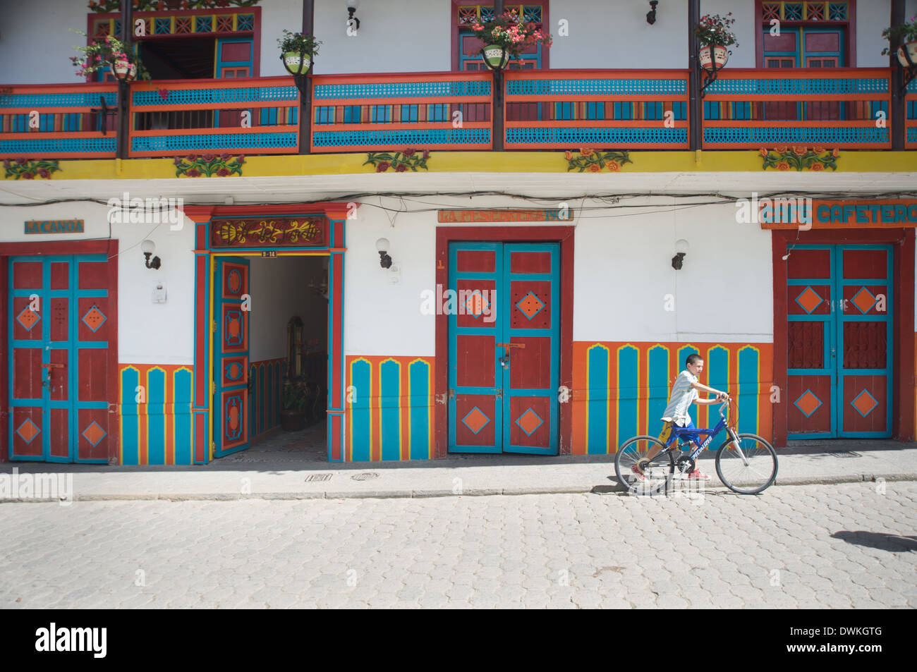 Junge geht seinem Fahrrad vorbei an bunten Architektur neben Jardin Plaza, Jardin, Antioquia, Kolumbien, Südamerika Stockfoto