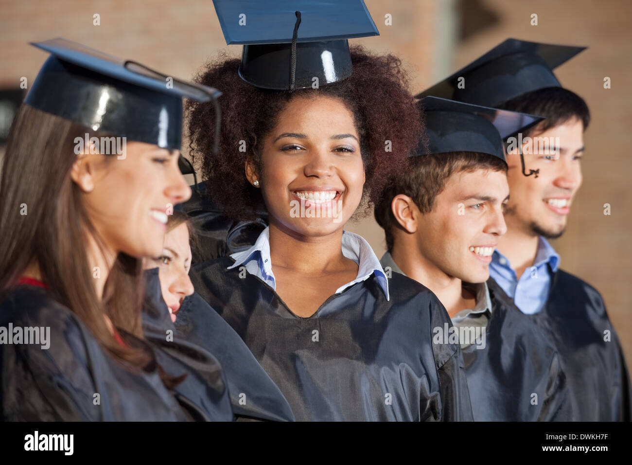 Frau mit Freunden am Abschlusstag am College Stockfoto