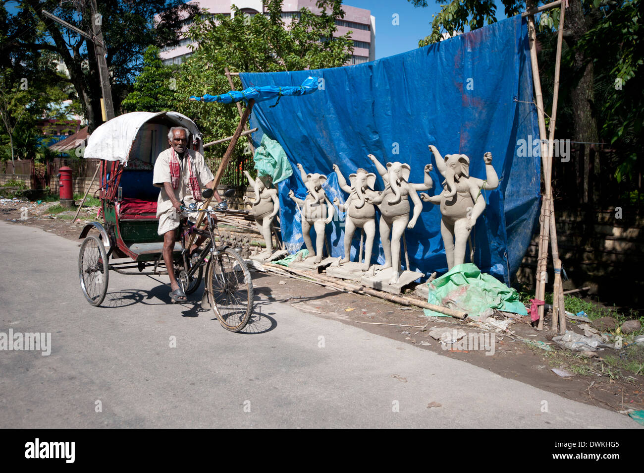 Fahrrad Rikscha vorbei Reihe von Ganesh Gottheiten in Vorbereitung auf Durga Puja feiern, Guwahati, Assam, Indien Stockfoto