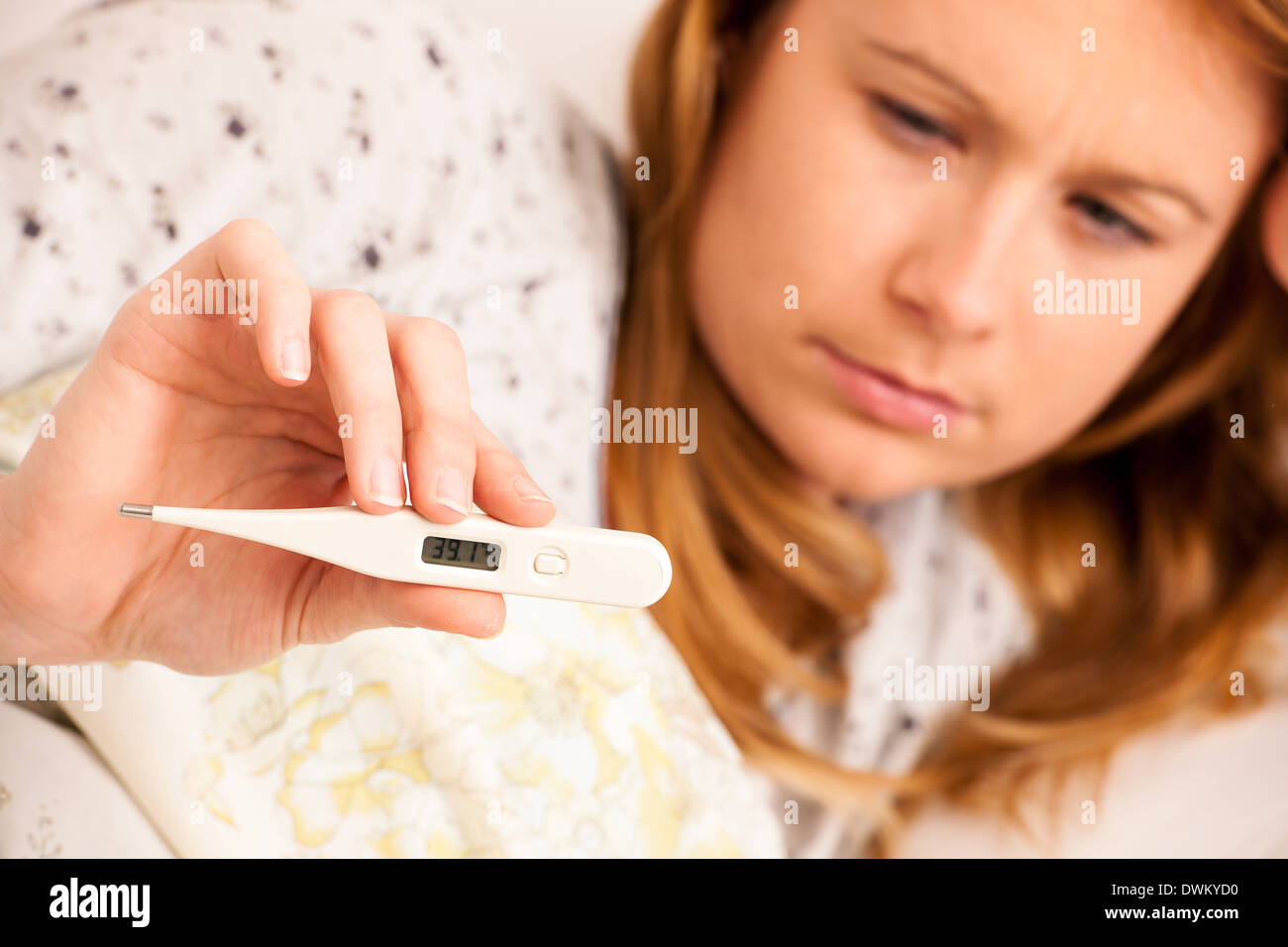 Frau Überprüfung Feaver mit digitalen Termomether Mädchen mit Grippe im Bett ruhen Stockfoto