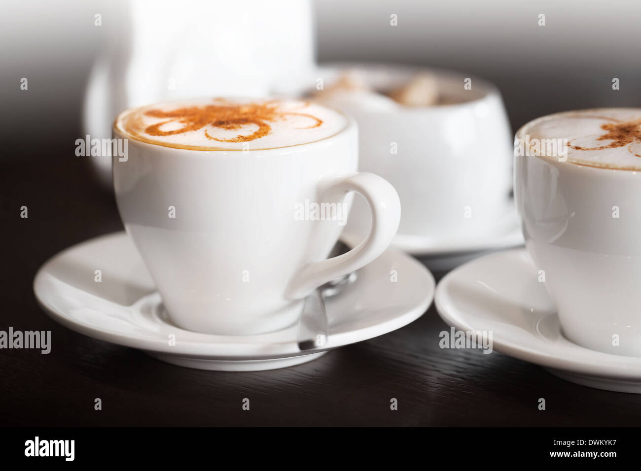 Weiße Tassen Cappuccino steht auf dunklen Holztisch Stockfoto