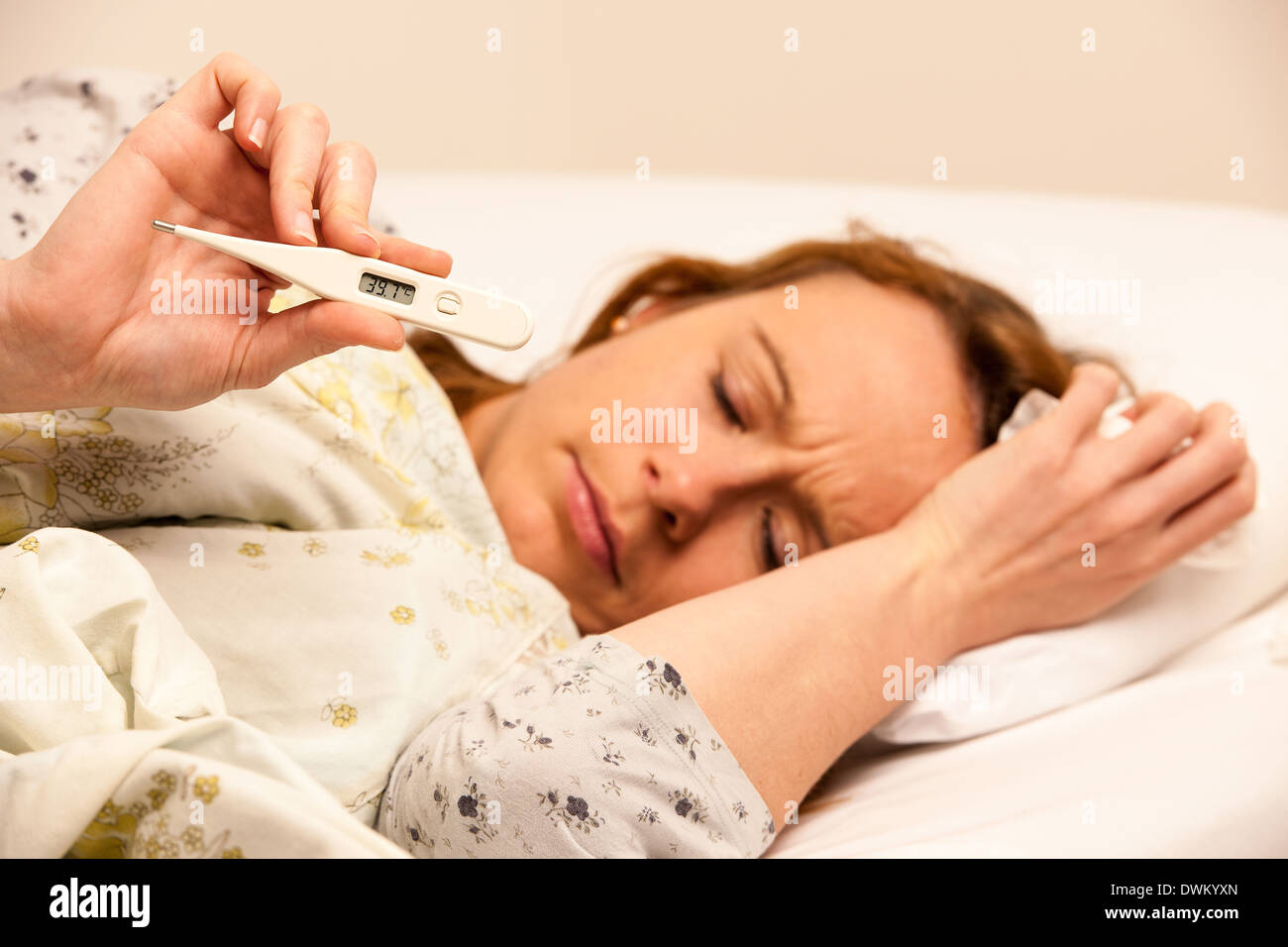 Frau Check-Fieber mit digitalen Termomether Mädchen mit Grippe im Bett ruhen Stockfoto