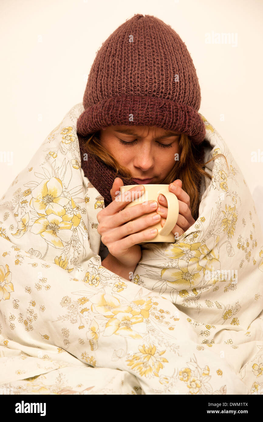 kranke Frau mit Feaver Tasse warmen Tee Unterdecke Stockfoto