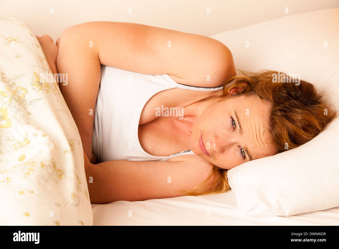 Frau Übelkeit mit Magenschmerzen im Bett - havy Schmerzen im Magen Stockfoto