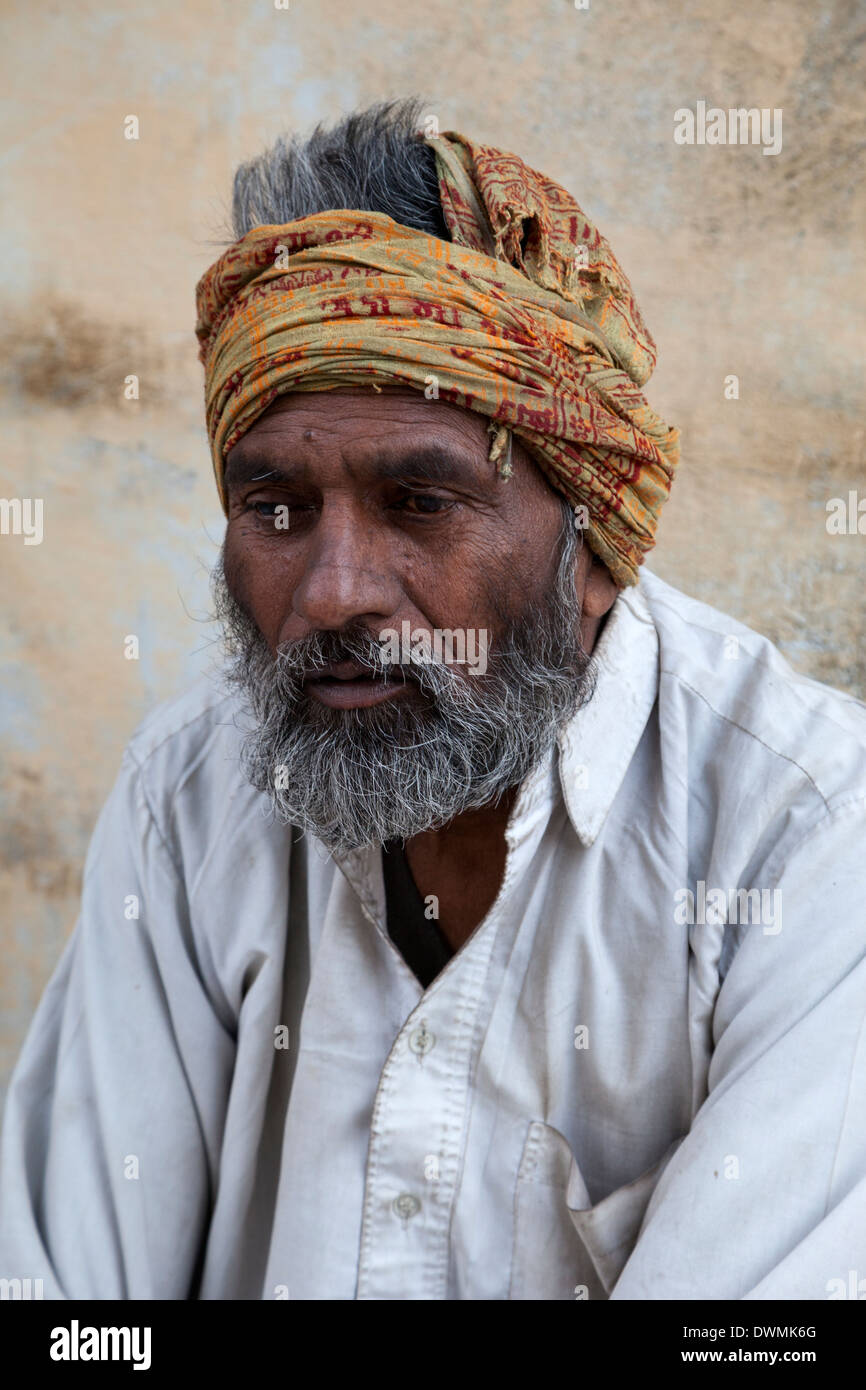 Jaipur, Rajasthan, Indien. Älterer Mann sitzt an der Seite der Straße. Stockfoto