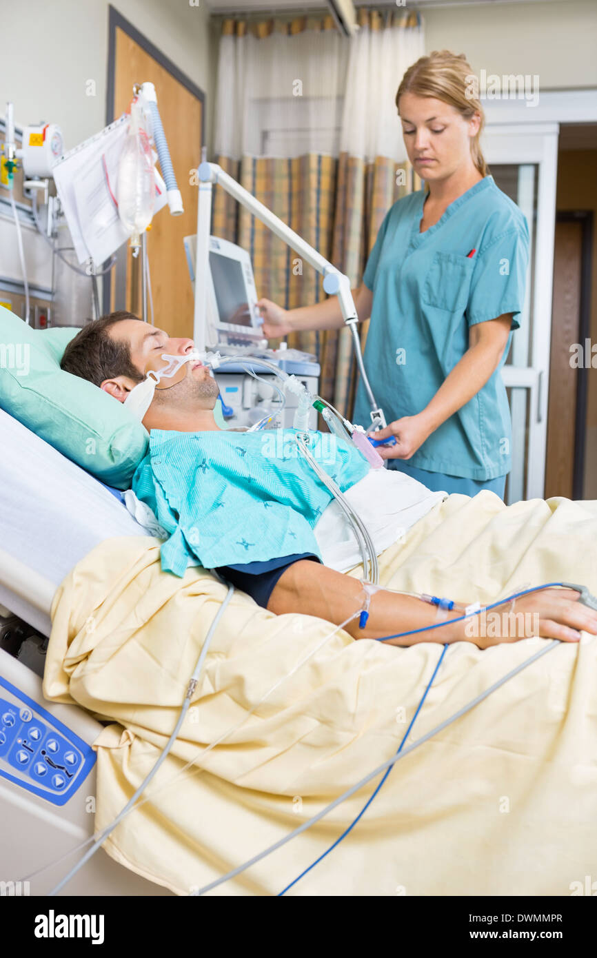 Krankenschwester untersuchen Patienten auf Bett liegend Stockfoto
