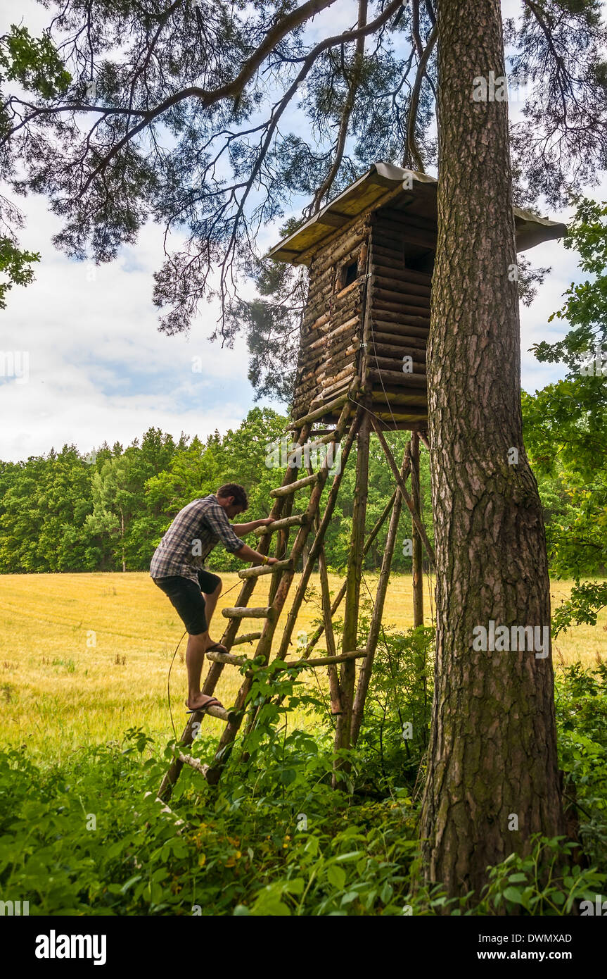 Mann, Klettern auf Jäger und Beobachtung Turm Stockfoto