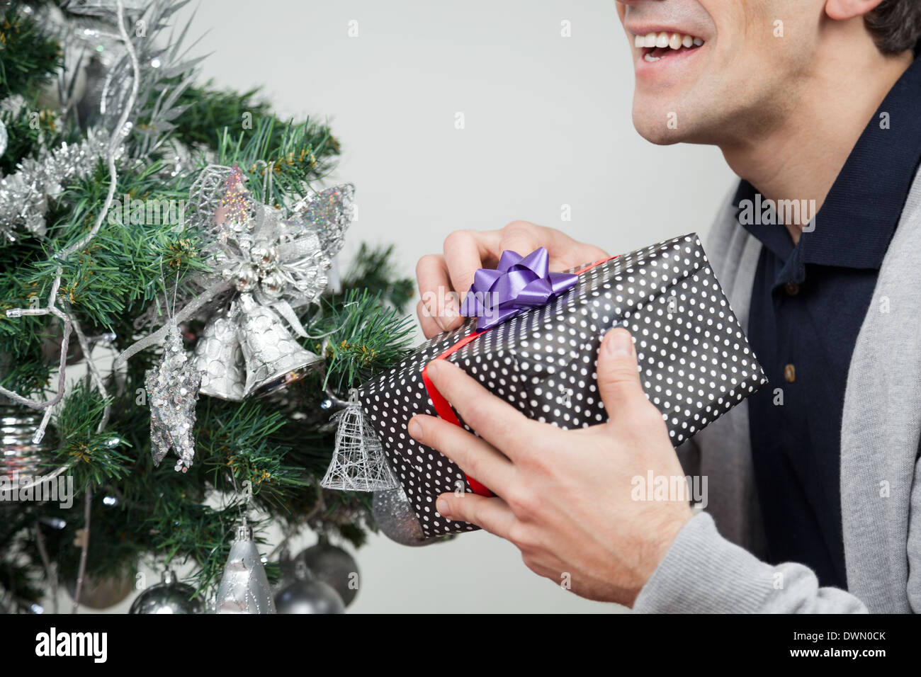 Mann mit Geschenk Weihnachtsbaum zu Hause Stockfoto