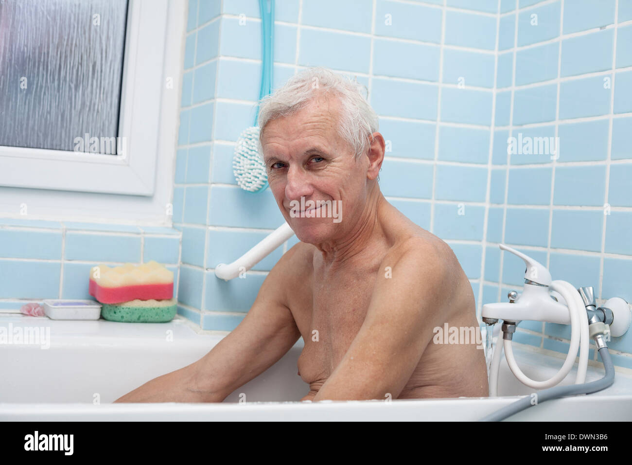 Porträt von glücklich senior Mann sitzt im Bad. Stockfoto
