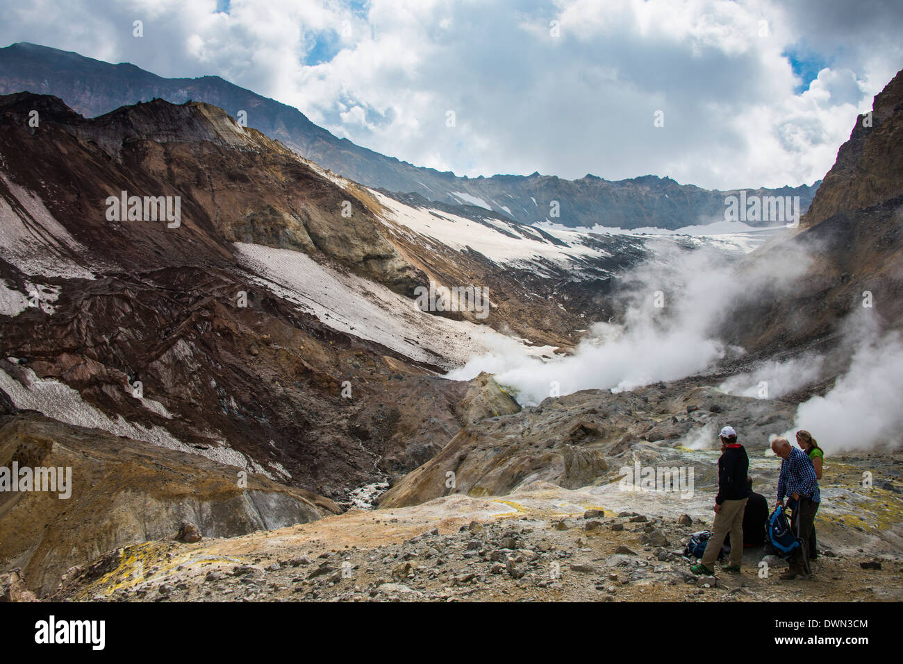 Touristen stehen durch Rauchen Fumarolen am Mutnowski Vulkan, Kamtschatka, Russland, Eurasien Stockfoto