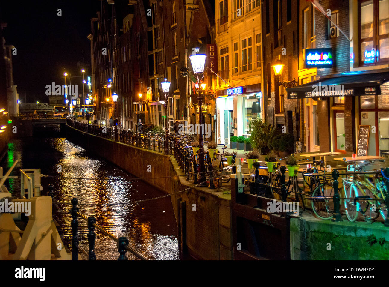 Amsterdamer Kanal in der Nacht mit Lichtern und Gebäude am Oudezijds Kolk und Zeedijk in der Nähe von Hotel France Stockfoto