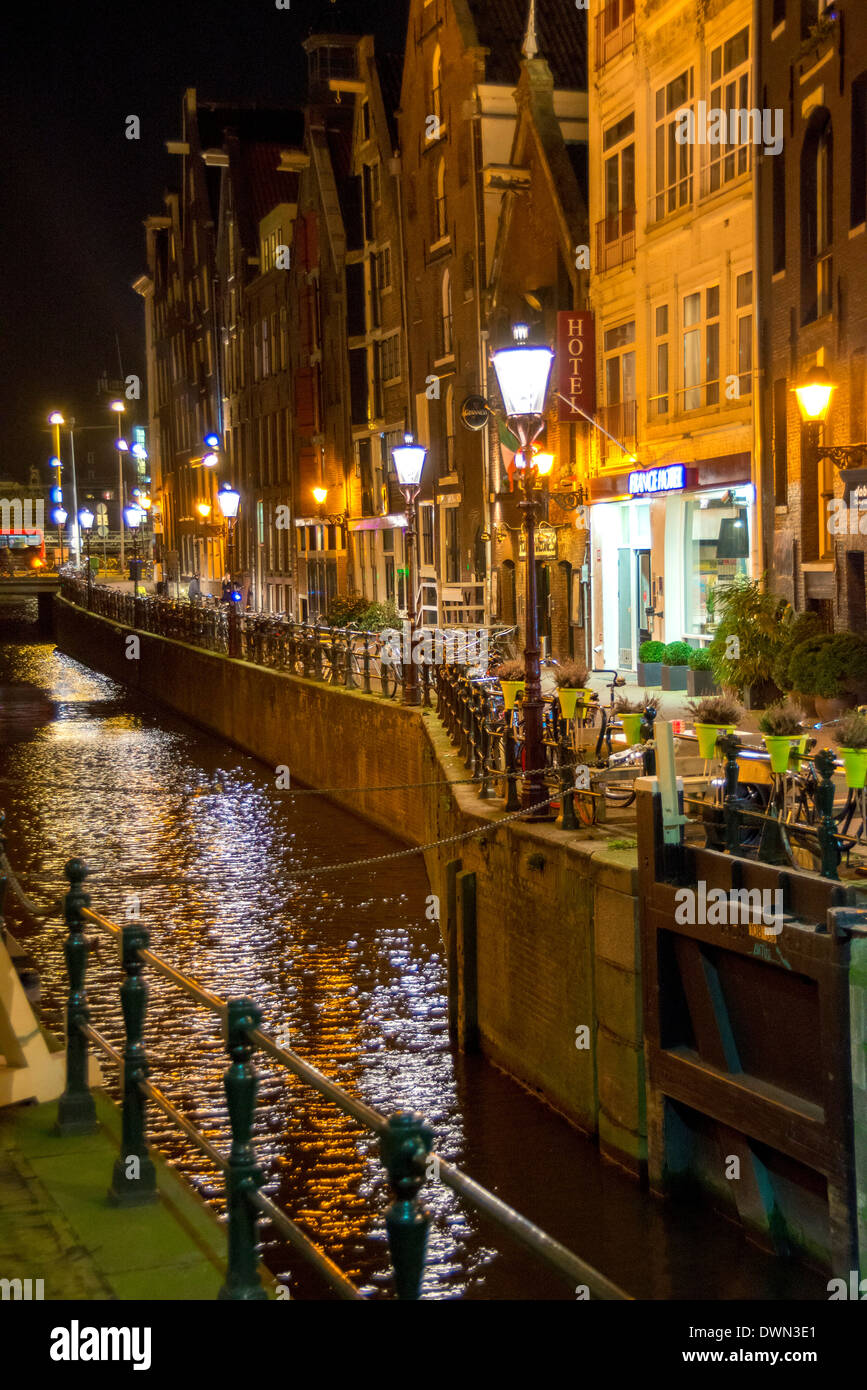 Amsterdamer Kanal in der Nacht mit Lichtern und Gebäude am Oudezijds Kolk und Zeedijk in der Nähe von Hotel France Stockfoto
