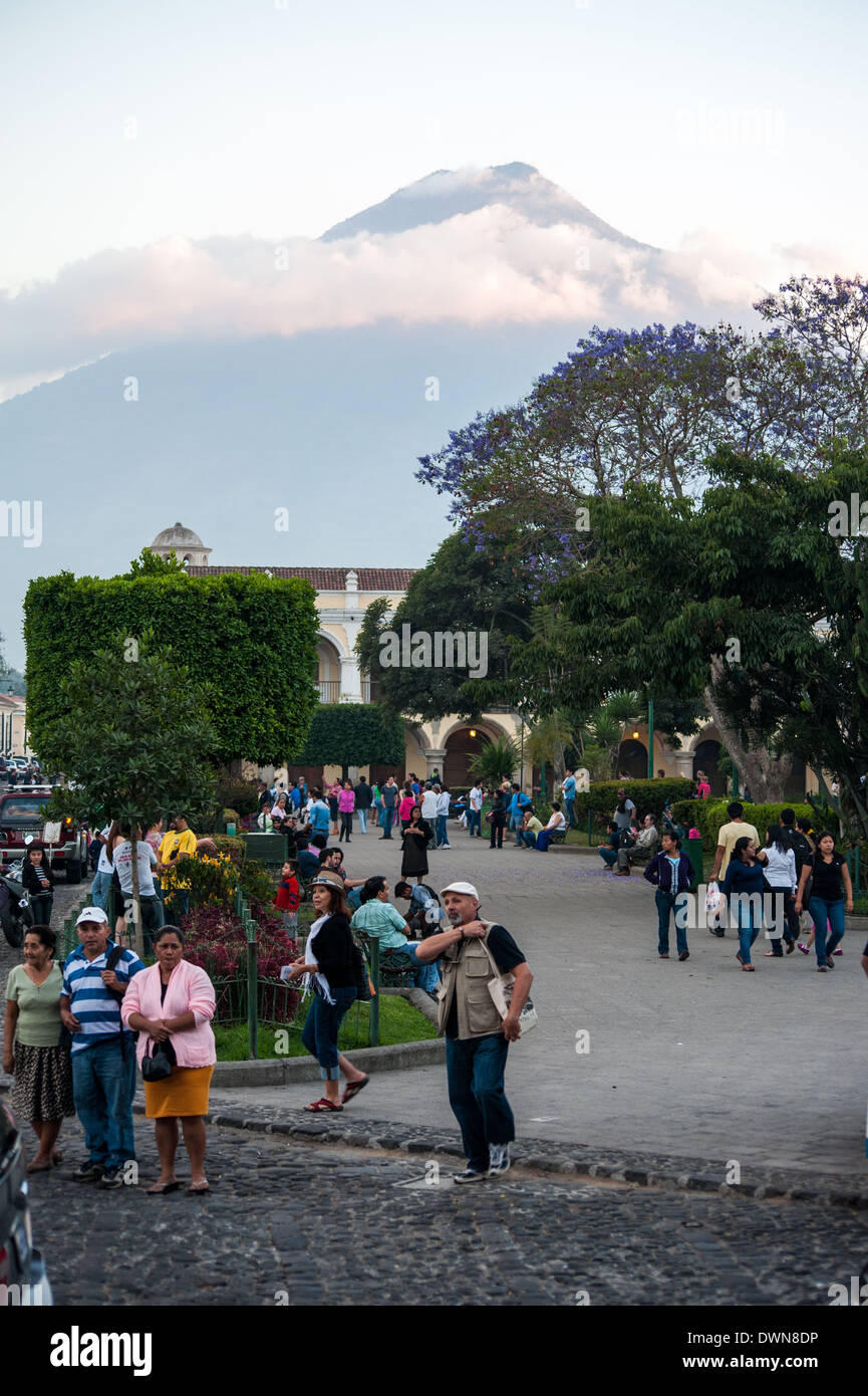 Menschen gehen über den Parque Central in Antigua, Guatemala mit Volcán de Agua Kommandeur der Hintergrundansicht. Stockfoto