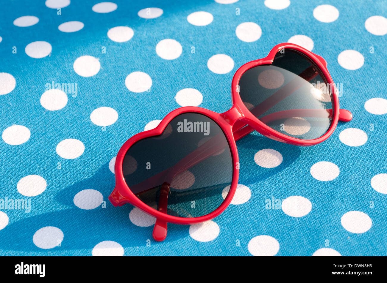 Red Heart shaped Sonnenbrille auf einem blau gepunkteten Tischmatte, 80er  Jahre style Sonnenbrillen, Vintage Sonnenbrillen Zubehör Konzept  Stockfotografie - Alamy