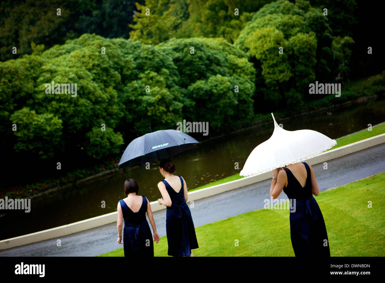 Brautjungfern wandern mit Schirm, die im Verlauf der Englischen Hochzeit. Stockfoto