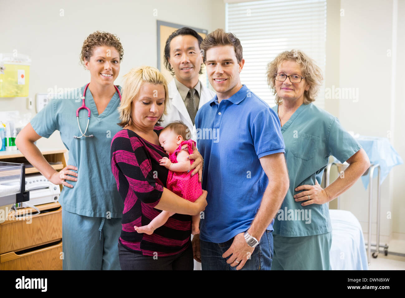 Ärzteteam mit Neugeborenen Mädchen und Eltern im Krankenhaus Stockfoto
