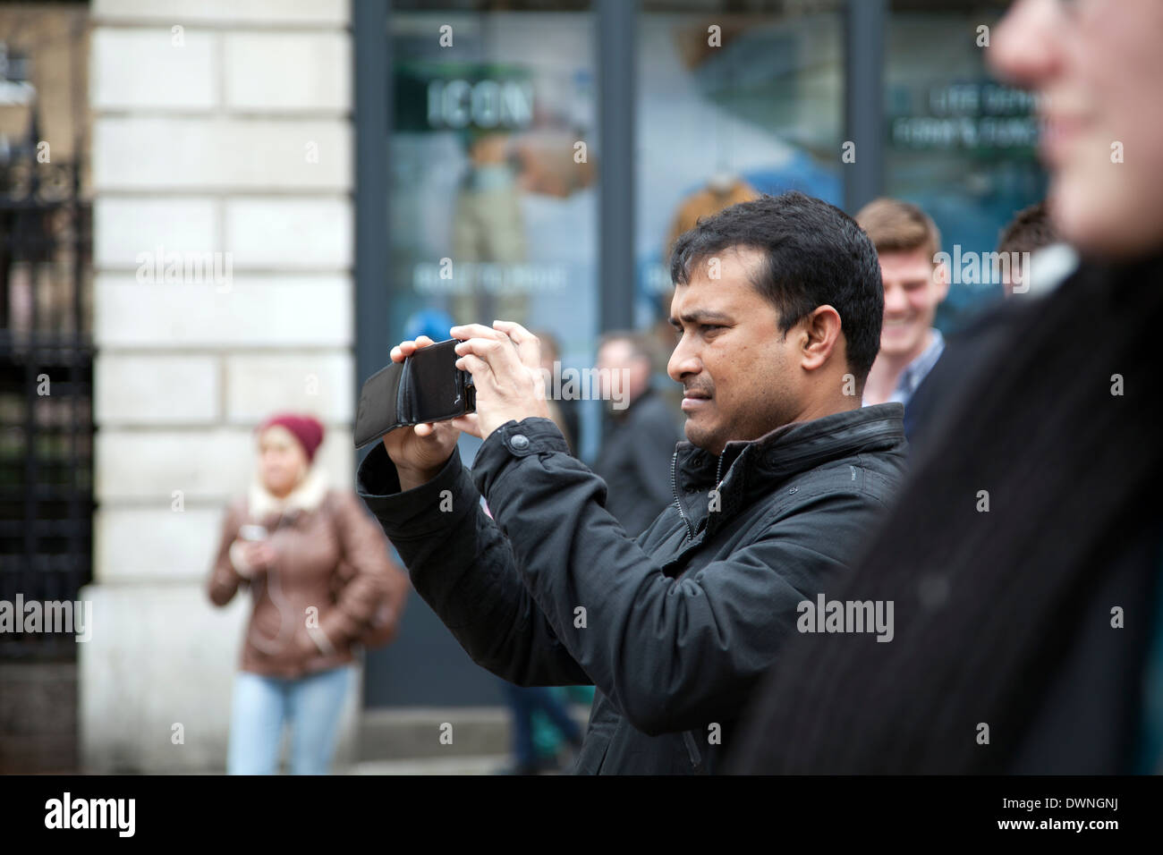 Mann mit mobilen Gerät fotografieren Darsteller am Covent Garden Market Stockfoto