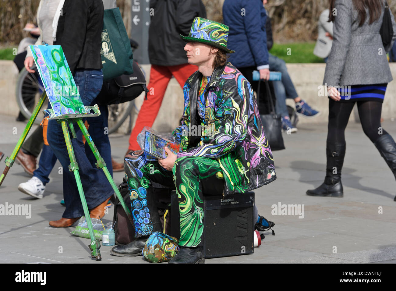 Streetart-Künstler im bunten Outfit sitzen Staffelei während Passanten in  Trafalgar Square, London, England, Vereinigtes Königreich Stockfotografie -  Alamy