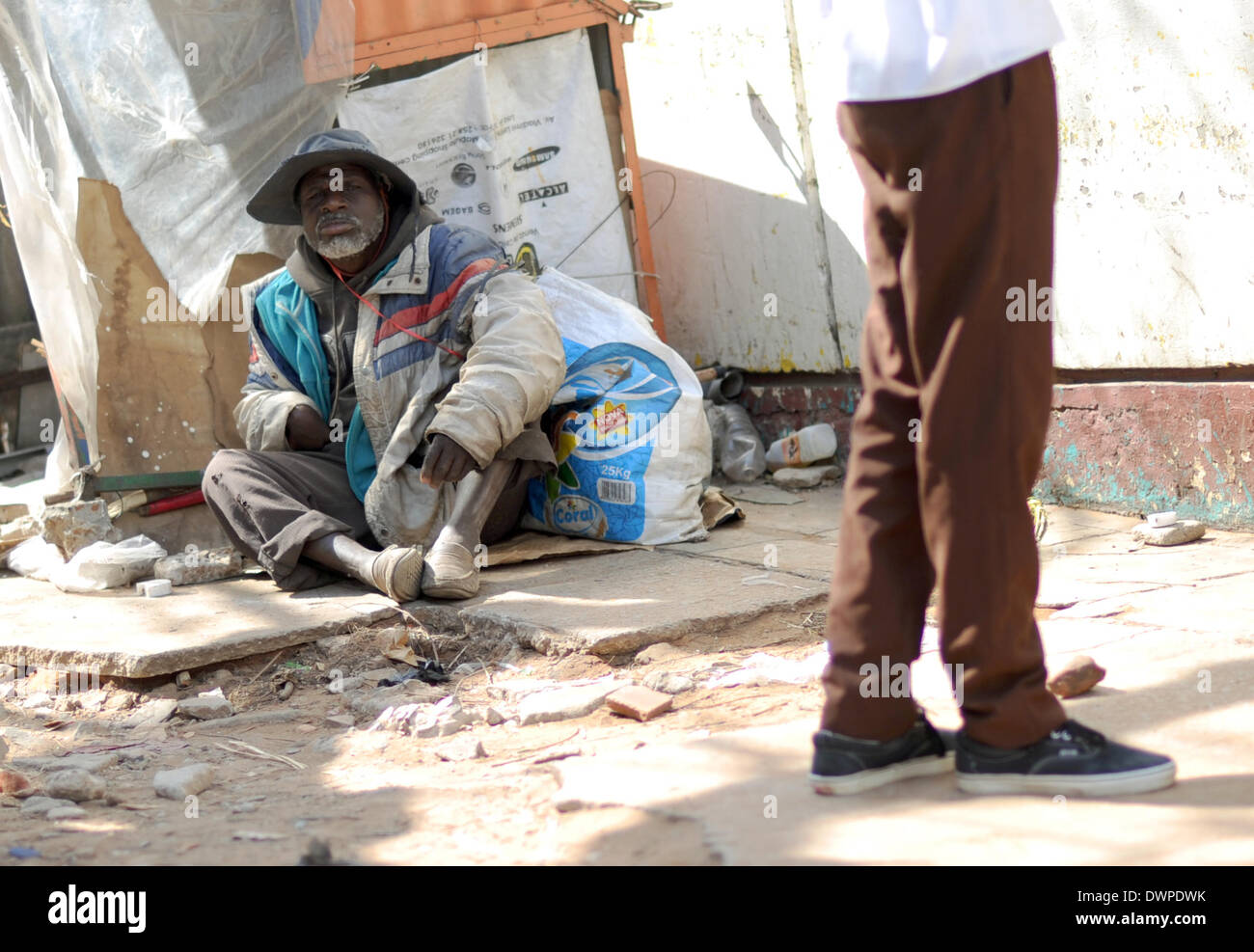 Maputo, Mosambik. 14. August 2013. Ein Mann geht vorbei an einem Obdachlosen in Maputo, Mosambik, 14. August 2013. Foto: Britta Pedersen - NO-Draht-SERVICE-/ Dpa/Alamy Live News Stockfoto
