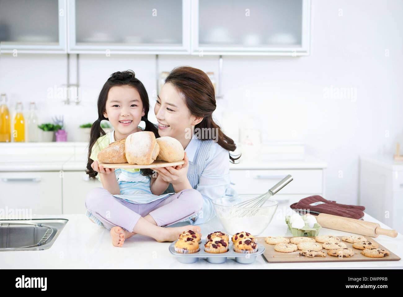 eine Mutter und eine Tochter mit einem Brett Brot Stockfoto