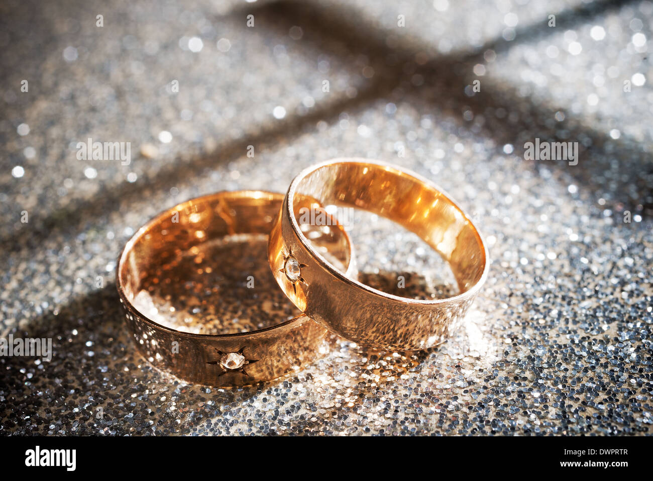 Goldene Hochzeit Ringe auf dem silbernen Hintergrund Stockfoto