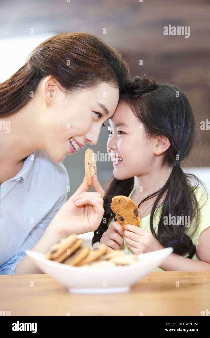 eine Mutter und eine Tochter, die Cookies in der Küche zu genießen Stockfoto