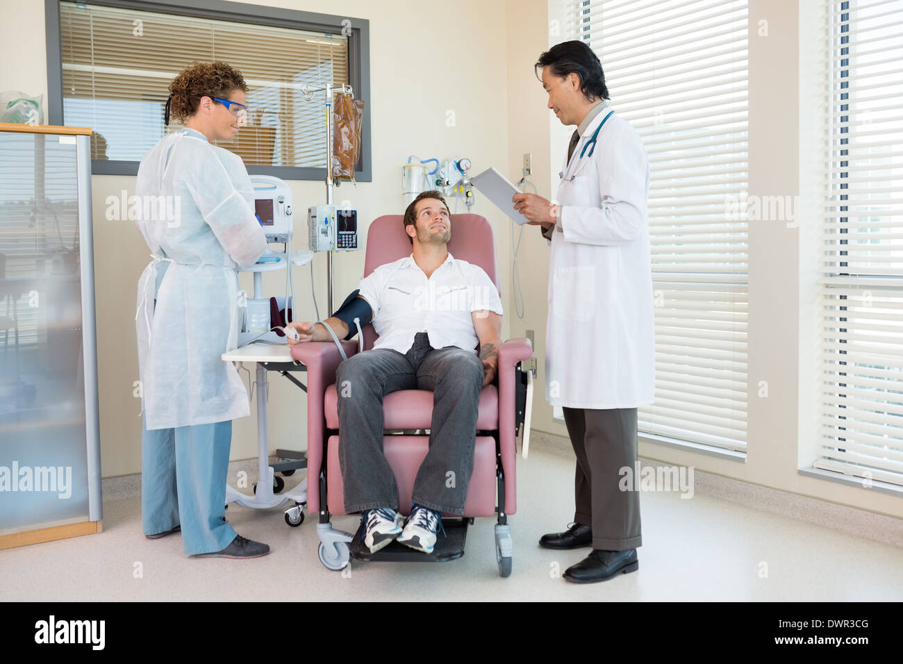 Patient Arzt Holding Digital Tablet im Krankenhaus Roo betrachten Stockfoto