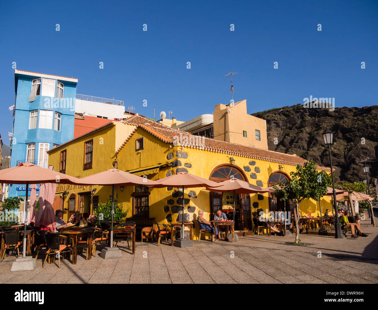Touristen sitzen im Restaurant "Taberna del Puerto" am Strand von Puerto de Tazacorte auf der Kanareninsel La Palma. Stockfoto