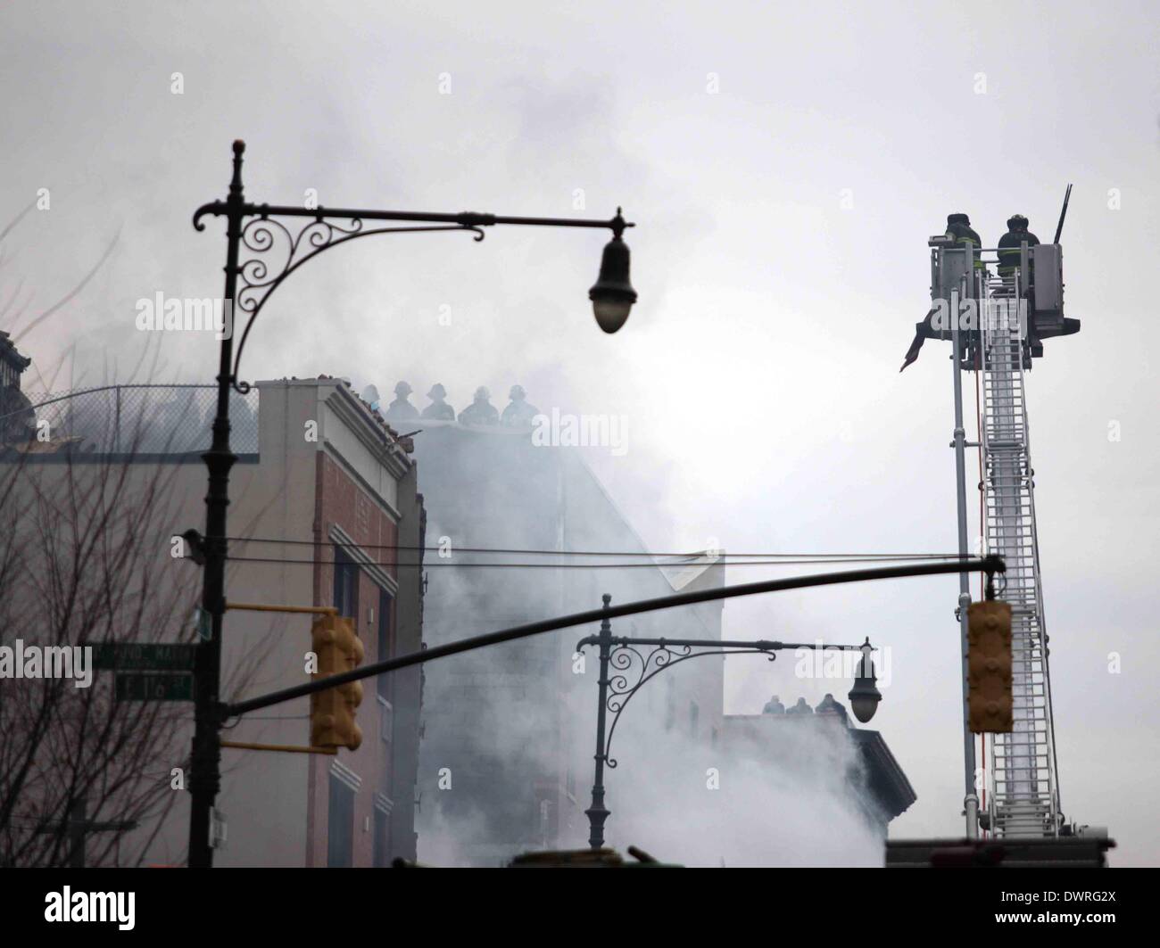 New York, USA. 12. März 2014. Feuerwehrleute arbeiten am Ort der Explosion im New Yorker East Harlem Nachbarschaft, 12. März 2014. Mindestens zwei Menschen wurden getötet und 18 weitere verletzt, als zwei Wohnhäuser am Mittwoch bei einer Explosion in New York East Harlem Nachbarschaft zusammenbrach Behörden sagten. Bildnachweis: Wu Rong/Xinhua/Alamy Live-Nachrichten Stockfoto