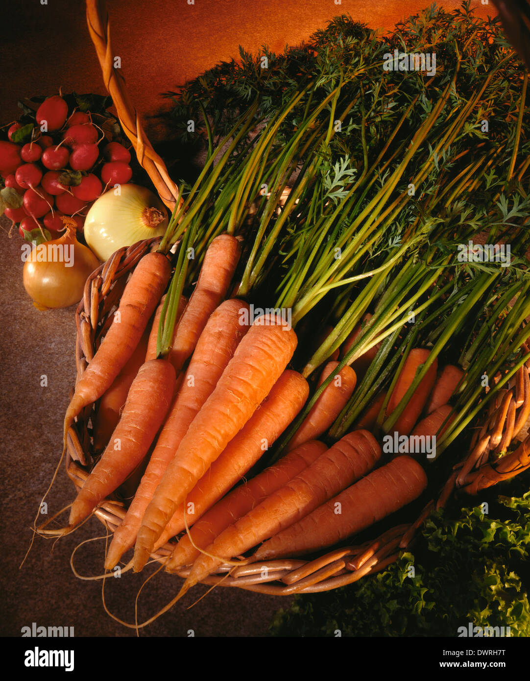 Ein Korb mit biologisch angebauten Karotten mit Zwiebeln und raddish Stockfoto