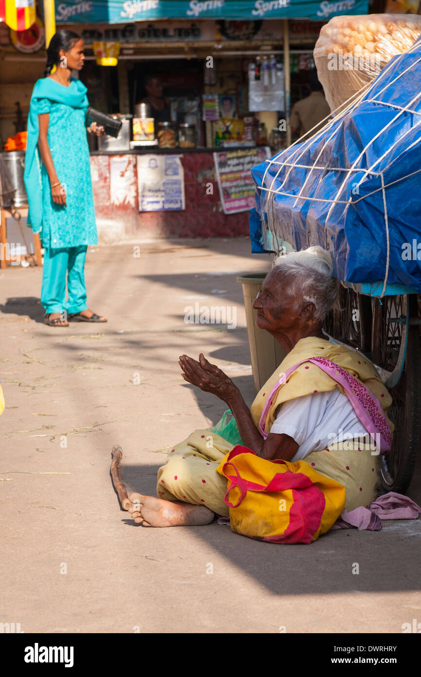 Süd Süd Indien Tamil Nadu Madurai Straßenszene grau graues Haar behaart alt Dame Frau weiblich sitzend auf Straße bittet betteln Stockfoto