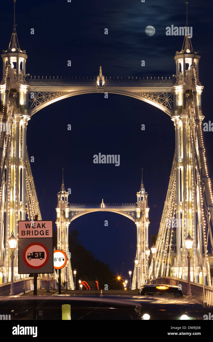 Albert Bridge über die Themse in London, mit Lichtern und der Mond scheint durch den Nachthimmel hinter geschmückt. Stockfoto