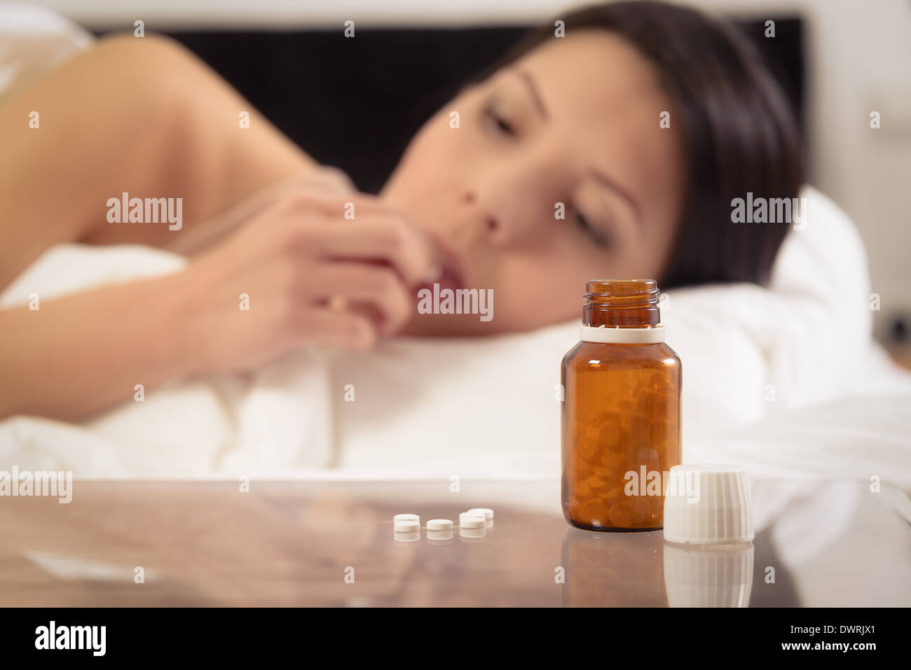 Eine Flasche von Tabletten auf einem Nachttisch Stockfoto