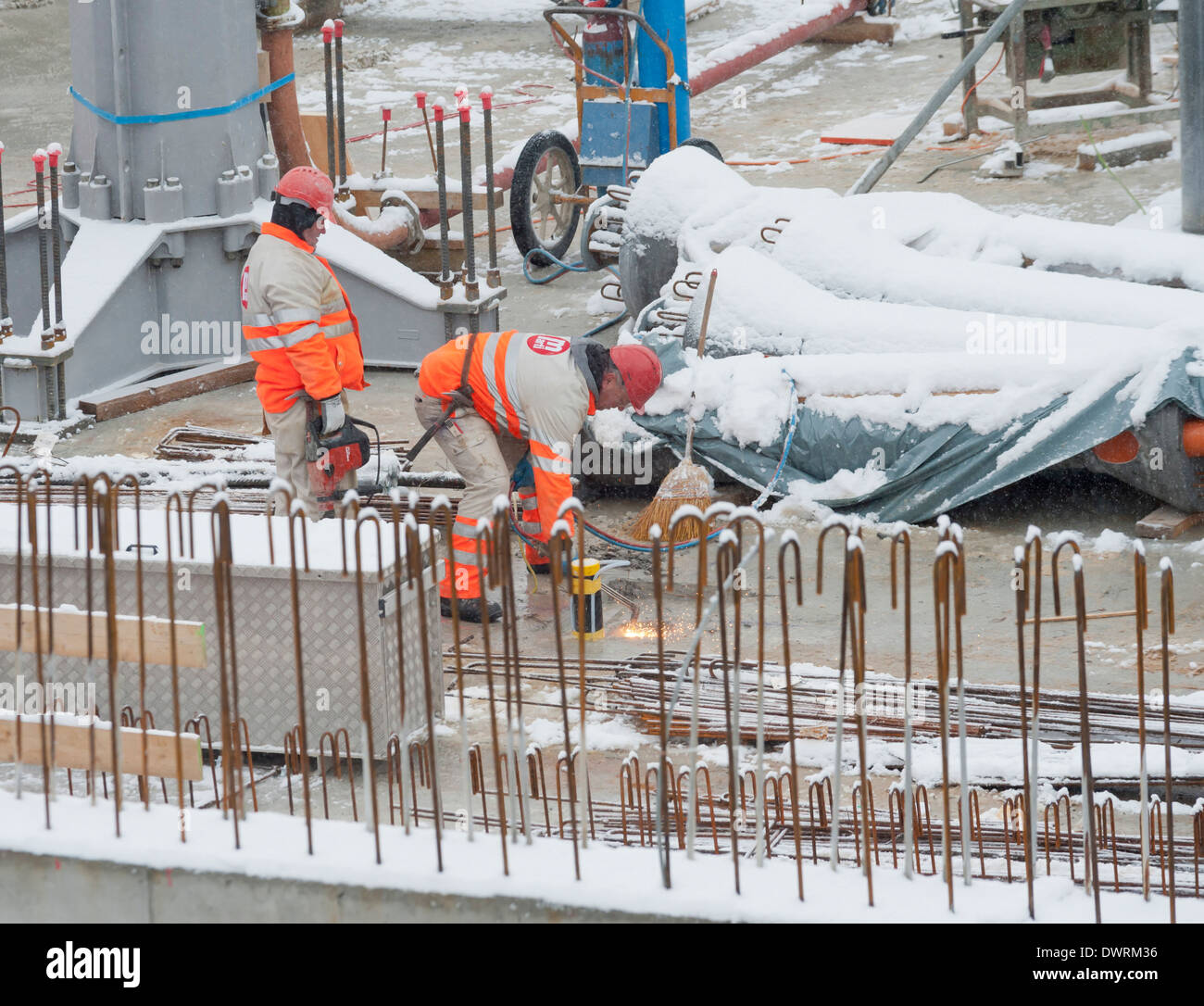 Bauarbeiter und Bautätigkeit auf einer verschneiten Winter-Baustelle in Zürich, Schweiz Stockfoto