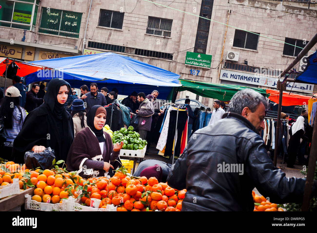 Zwei Frauen sprechen mit einem Lieferanten, da sie Obst auf dem Freitag-Markt in der Abdali Stadtteil von Amman kaufen, Jordanien. Stockfoto