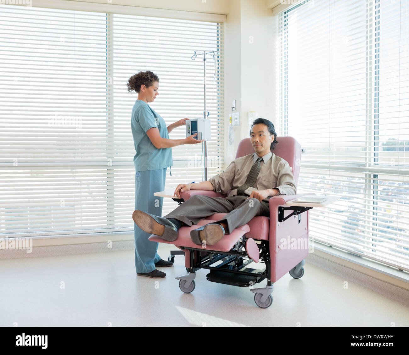 Krankenschwester-Betrieb-IV-Maschine für Patienten während der Chemotherapie Stockfoto