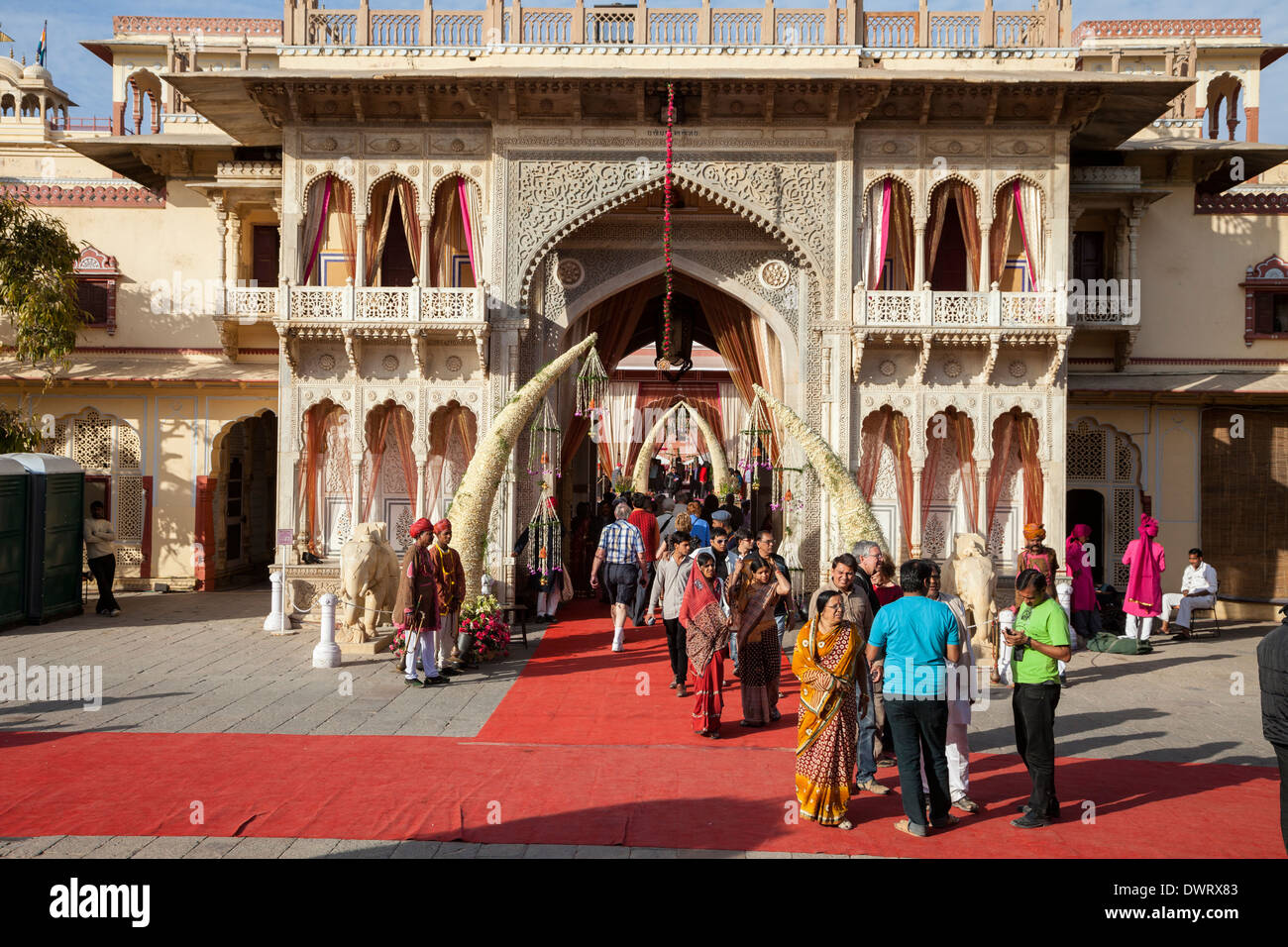 Jaipur, Rajasthan, Indien. Touristen betreten, Exiting Jaipur City Palace, vorbereitet für eine Hochzeitsfeier Nachmittag. Stockfoto