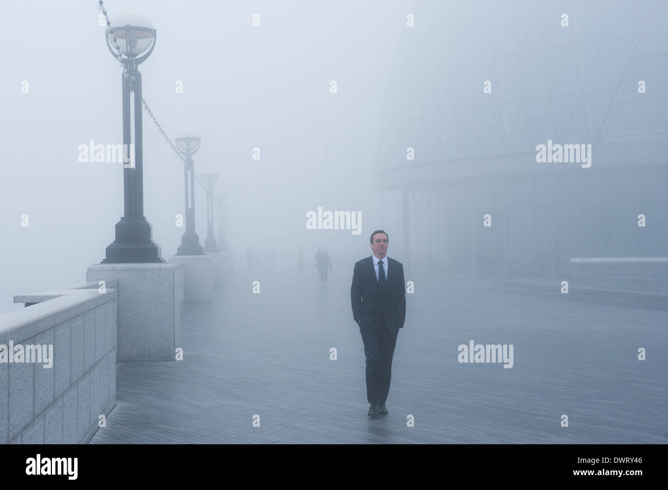 London, UK. 13. März 2014. ein Geschäftsmann geht in der Nähe von Tower Bridge als London unter dichtem Nebel Credit aufwacht: Piero Cruciatti/Alamy Live News Stockfoto