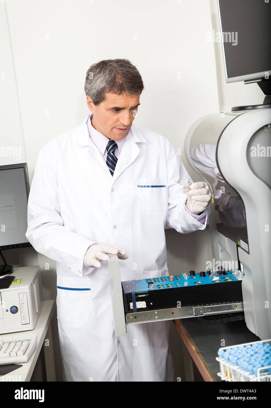 Wissenschaftler-laden-Analyzer mit Proben Stockfoto