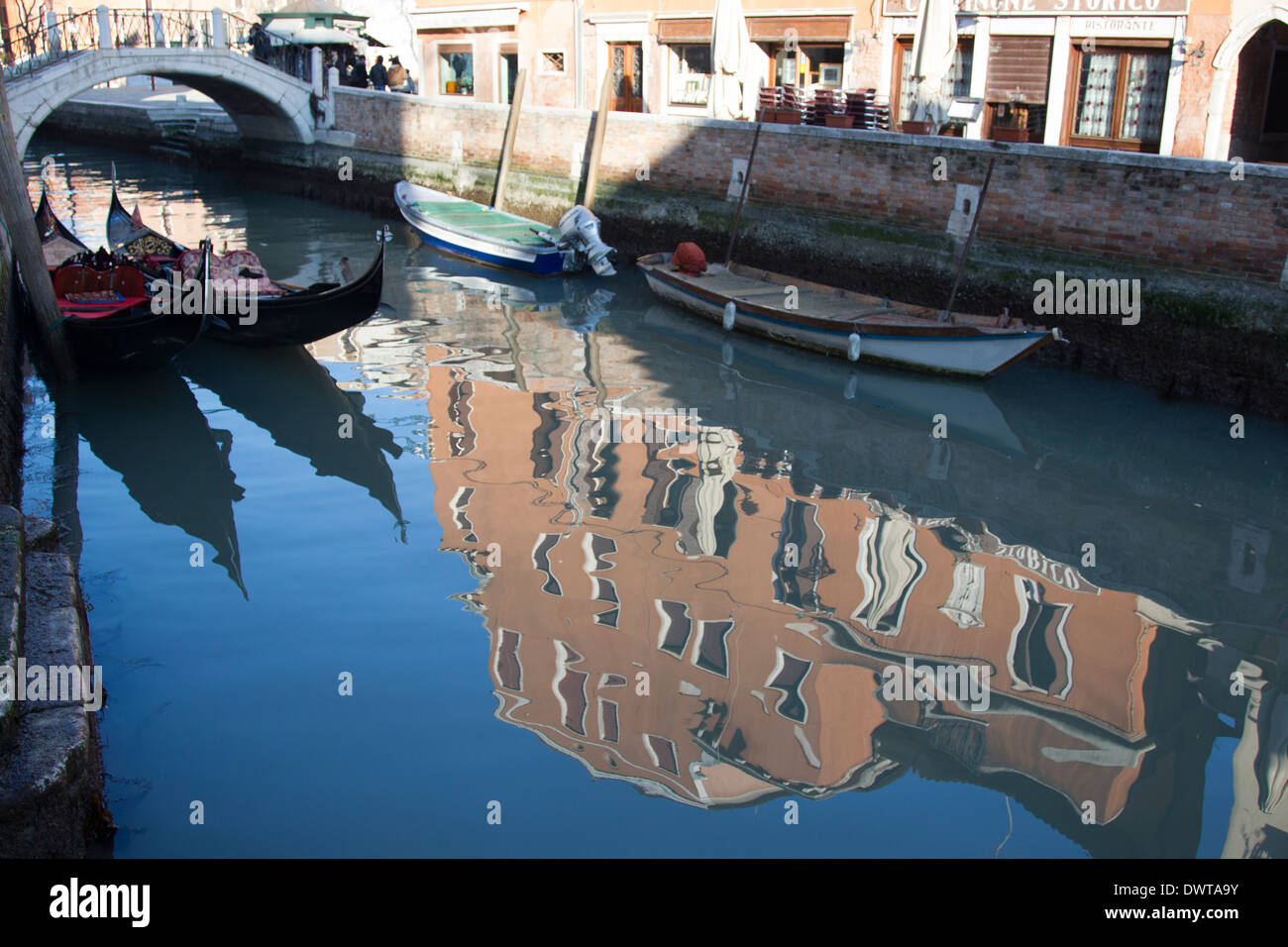 Reflexionen auf dem Wasser in Venedig Kanal bauen. Eine Fußgänger Fußgängerbrücke kann im Hintergrund zu sehen. Stockfoto