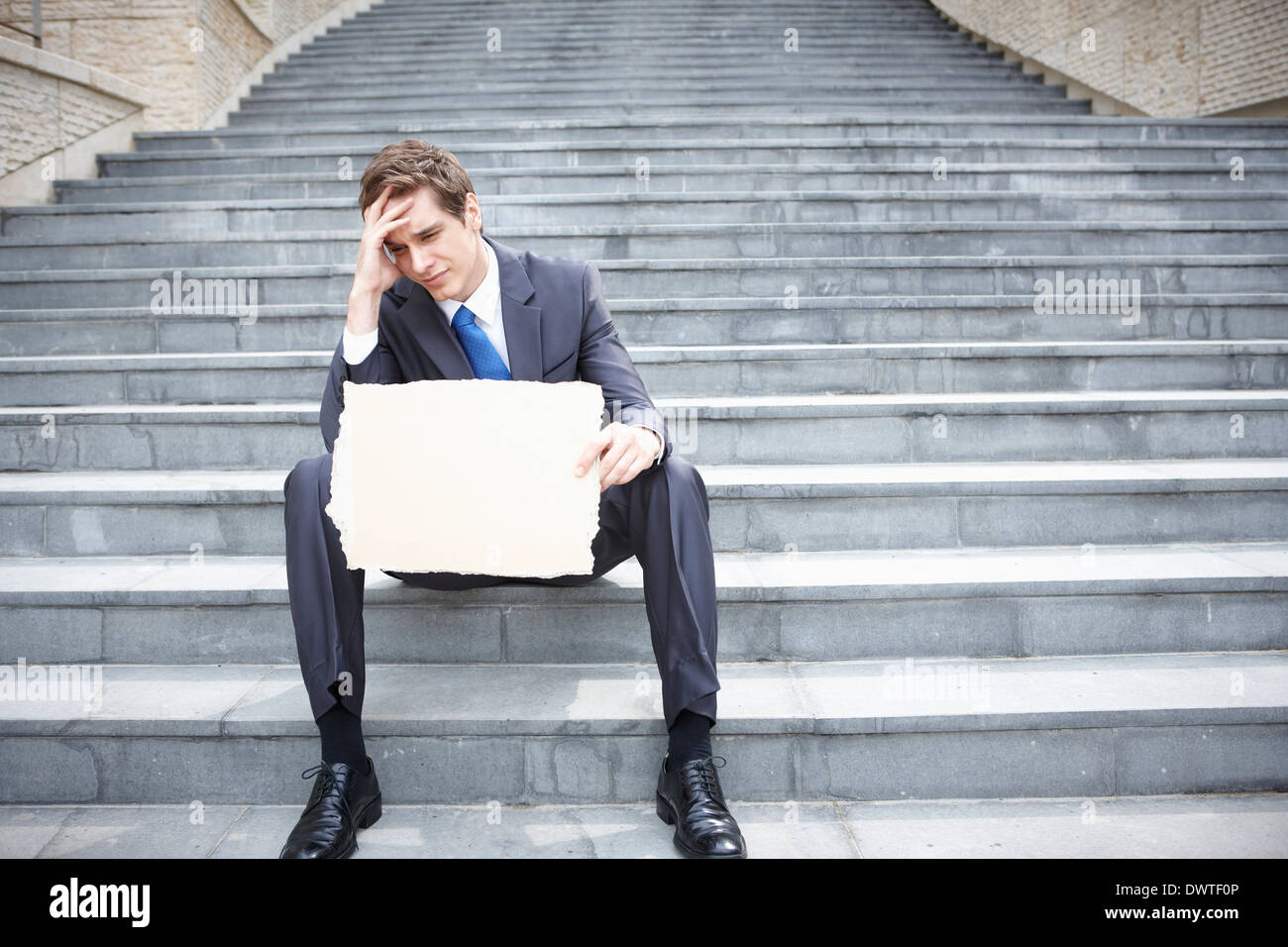 ein Business-Mann sitzt auf der Treppe mit einem Textfreiraum Stockfoto