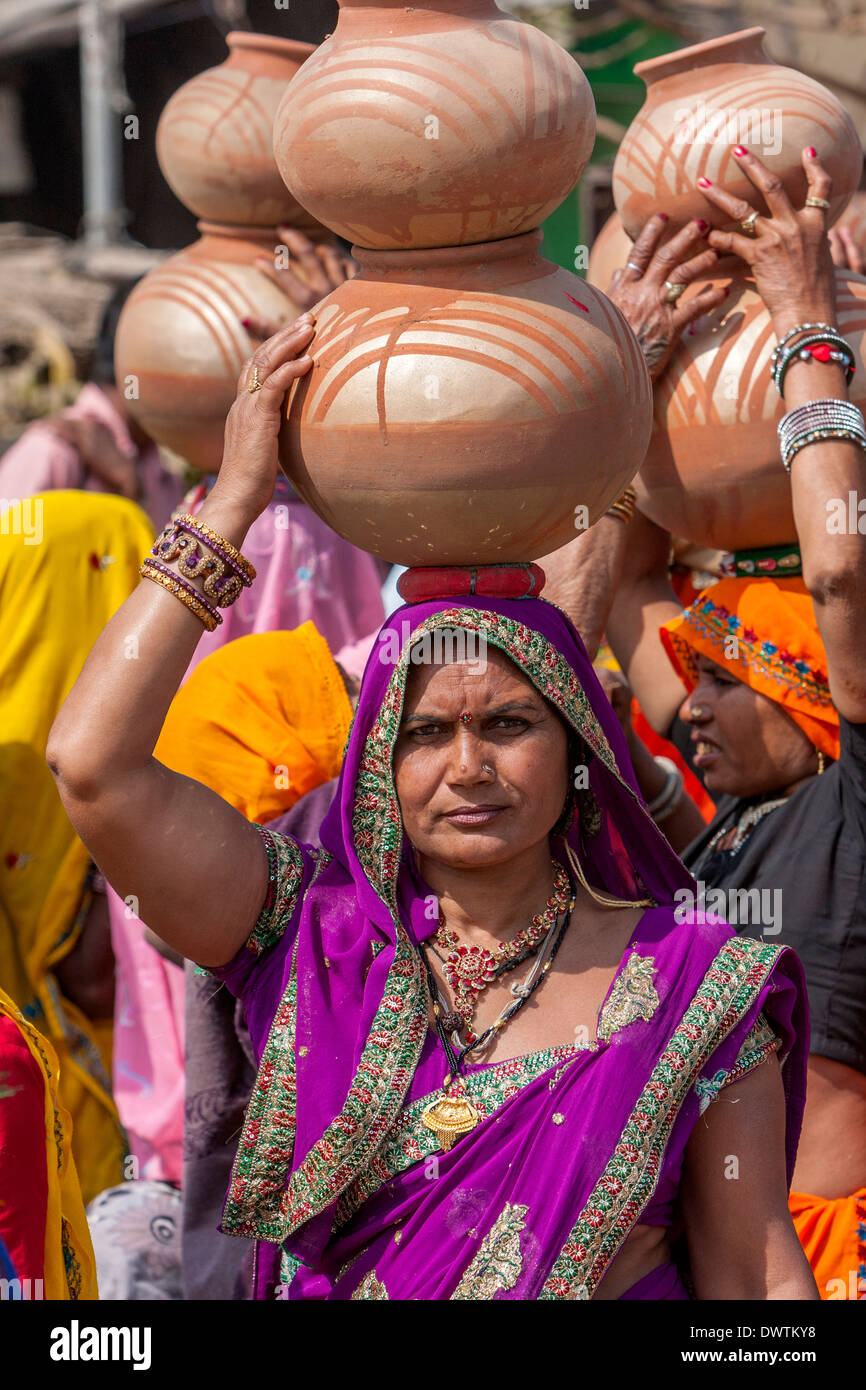 Abhaneri, Rajasthan, Indien. Frauen tragen Töpfe auf dem Kopf, als sie in ein Pre-Wedding-fest teilnehmen. Stockfoto